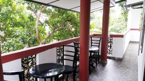 a balcony with two tables and chairs and trees at Green Garden Guest Mirissa in Mirissa