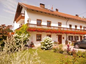 a large white house with flowers in front of it at Holzhauser Hof in Waldkraiburg