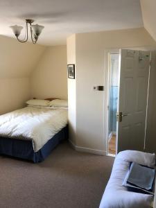 a bedroom with a bed and a couch next to a door at Old Police House in Aultbea