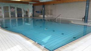 a large swimming pool with blue tiles on the floor at VVF Résidence Golfe du Morbihan in Larmor-Baden +16 photos