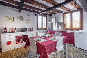 a kitchen with a table with a red table cloth at Ca Alle Guglie in Venice