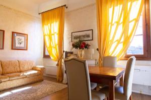 a living room with a wooden table and yellow curtains at Magic Signoria Apartment in Florence