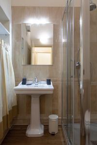 a bathroom with a sink and a glass shower at Magic Signoria Apartment in Florence