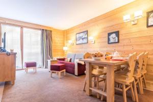 a living room with a table and a couch at Résidence Les Chalets du Forum - Courchevel 1850 in Courchevel