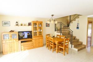 a dining room and kitchen with a table and a television at Olivers Planet Costa Dorada in Cambrils