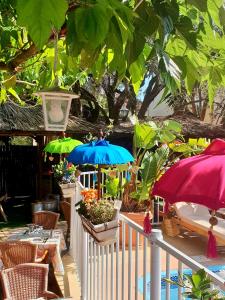 een patio met parasols, stoelen en planten bij Le Mas de la Frigoulette in Sanary-sur-Mer