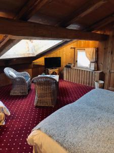 een slaapkamer met een bed en stoelen op een zolder bij Le Coin Savoyard in Combloux