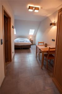 1 dormitorio con 1 cama y 1 mesa en una habitación en B&B D'Hollehoeve en Heist-op-den-Berg