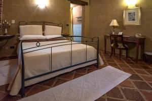 1 dormitorio con 1 cama y 1 mesa con lámpara en Le Soleil, en Vigone