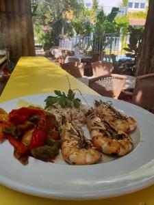 a plate of food with shrimp and vegetables on a table at Le Mas de la Frigoulette in Sanary-sur-Mer