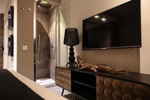 a room with a television and a statue of a cat and a lamp at Neko Boutique Hotel in Cagliari