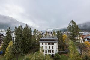 a large white house on top of a hill at Apartment Chamois Blanc 6 - Chamonix Haven with great views in Chamonix-Mont-Blanc