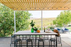 a patio with a table and chairs under a wooden pergola at CAMBEIROS - Guest House in Alenquer