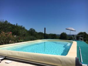 Luxury Villa in Cazals with Swimming Pool في Cazals: مسبح مع مظله وكرسي