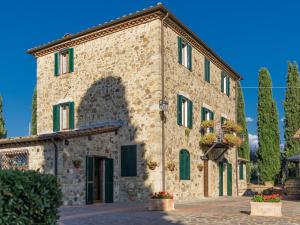 un gran edificio de piedra con persianas verdes en Belvilla by OYO Casa del Re, en Le Piazze
