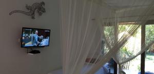 a television in a room with curtains and a window at Nalini Resort in Amed