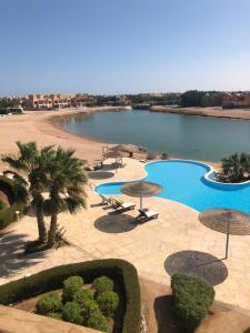 a swimming pool with umbrellas and a body of water at Dar Om Ali ElGouna Sabina y160 2 14 in El Gouna