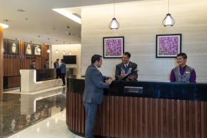
a man standing next to a woman in front of a counter at Park Regis Business Bay in Dubai
