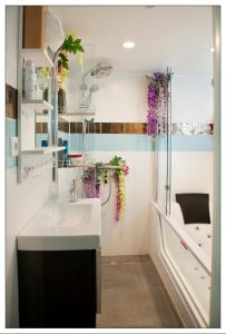 La salle de bains est pourvue d'un lavabo et d'une douche avec des fleurs violettes. dans l'établissement Private guesthouse BnB The Waterhouse houseboat, à Amsterdam