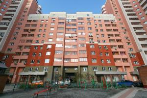 un edificio de apartamentos con un parque infantil delante de él en Apartments Freedom, en Novosibirsk