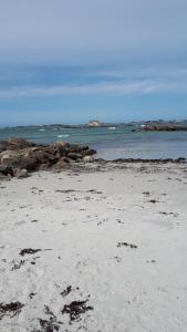 una spiaggia sabbiosa con rocce in acqua di La Chambre d'Alexandre a Santec Altre 5 foto