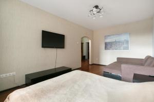 ein Hotelzimmer mit einem Bett und einem Flachbild-TV in der Unterkunft Apartments Freedom in Nowosibirsk