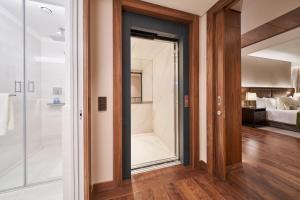 a bathroom with a shower and a glass door at Les Suites at The Cliff Bay - PortoBay in Funchal