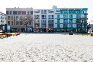 a large plaza with benches and buildings in a city at Jantar Apartamenty Design Latarnia Morska in Kołobrzeg