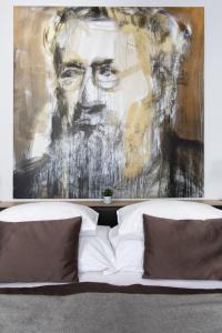 a painting of a man sitting on a bed at Design Hotel Neruda in Prague