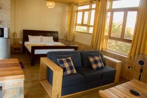 a living room with a couch and a bed at Nile Front Cottages in Jinja