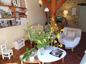 uma sala de estar com uma mesa com flores em Le Moulin de Drapras em Chemillé