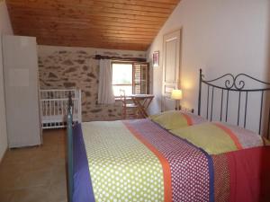 um quarto com uma cama com um cobertor colorido em Le Moulin de Drapras em Chemillé