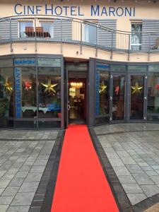 ツィルンドルフにあるCineHotel Maroniの赤い床のホテル前の赤い絨毯