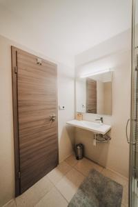 a bathroom with a sink and a wooden door at Beautiful new studio, 400m from the square in Plzeň