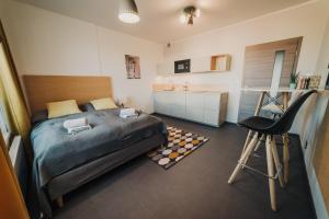 a bedroom with a bed and a sink and a chair at Beautiful new studio, 400m from the square in Pilsen