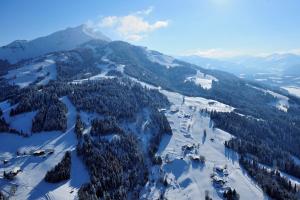 eine Luftansicht auf einen Berg mit Schnee und Bäumen in der Unterkunft Hotel Sonne in Sankt Johann in Tirol