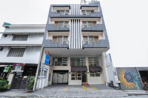 un edificio blanco alto con muchas ventanas en Alley 8 Makati, en Manila