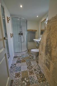 y baño con ducha, aseo y lavamanos. en Magic in the Heart of Old Gozo (Penthouse), en Victoria
