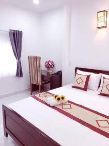 um quarto com uma cama, uma cadeira e uma mesa em Aurora Hotel em Ho Chi Minh