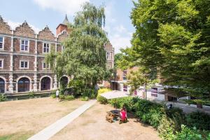 un gruppo di persone che si trovano di fronte a un edificio di Safestay London Kensington Holland Park a Londra