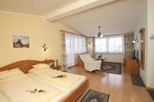 a bedroom with a bed and a chair in a room at Hotel Sonne in Sankt Johann in Tirol