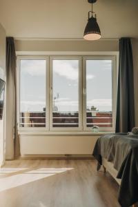Schlafzimmer mit einem großen Fenster mit Aussicht in der Unterkunft New equipped apartment in the city center in Pilsen