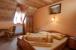 a bedroom with a bed and a table and a window at PENZIONHARMONIA eu in Lendak