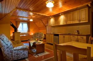 a kitchen with wooden cabinets and a table and chairs at PENZIONHARMONIA eu in Lendak