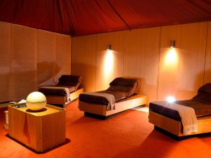 a room with three beds and a table and lights at Hotel de France in Saint Helier Jersey