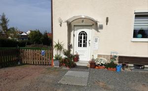 ein Haus mit einer weißen Tür und einigen Topfpflanzen in der Unterkunft Ferienwohnung Wendehake in Quedlinburg