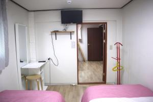 Cette chambre dispose d'un lit et d'une porte menant à un couloir. dans l'établissement Jeong House, à Séoul