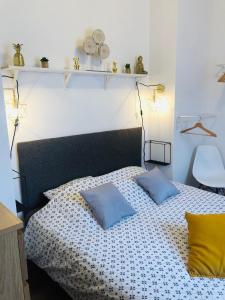 um quarto com uma cama com duas almofadas em L’Annexe em LʼÉpine