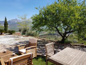 una mesa y sillas con una mesa y un árbol en Casita Las Melosillas, en Casabermeja