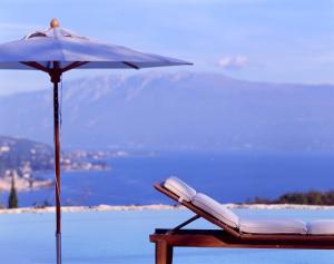 a chair with an umbrella next to the ocean at Villa Arcadio in Salò